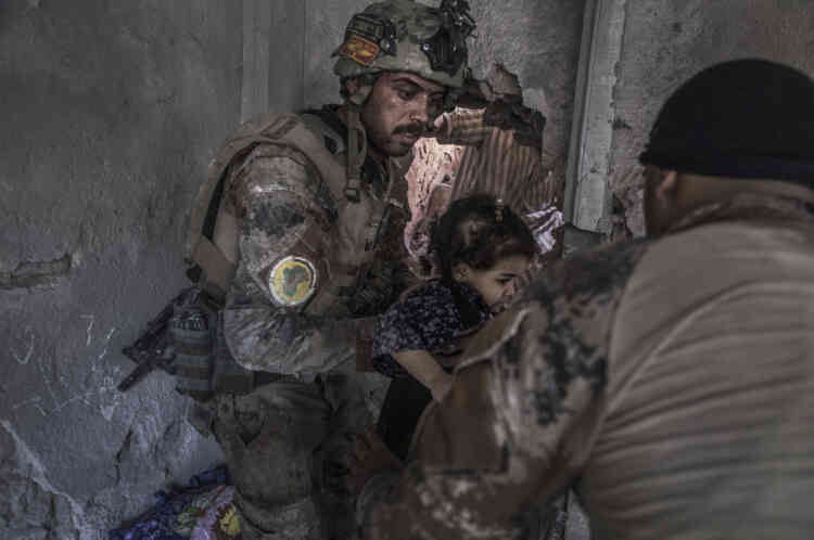 Des soldats des forces spéciales évacuent des enfants par une ouverture faite à la masse quelques minutes plus tôt.