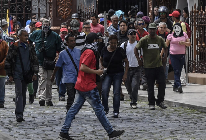 Des partisans du président Maduro pénètrent dans l’enceinte du Parlement vénézuélien tenu par l’opposition, mercredi 5 juillet à Caracas.