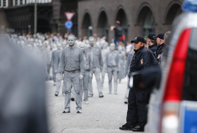Des manifestants couverts d’argile ont défilé contre le G20, mercredi 5 juillet, à Hambourg, dans le cadre de la performance anticapitaliste « 1 000 Gestalten » (« 1 000 silhouettes »).
