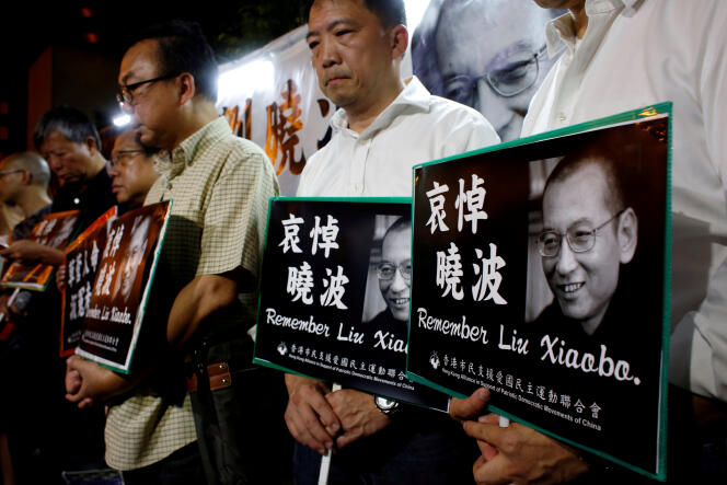 Des militants pour la démocratie pleurent la mort de l’opposant Liu Xiaobo, devant le bureau de liaison du gouvernement central chinois à Hongkong, le 13 juillet.
