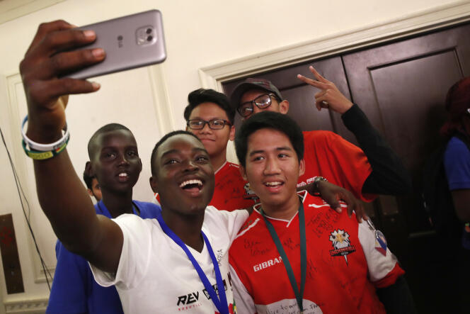 Mawuena Yves Date, du Togo, prend un selfie avec des lycéens de l’équipe sud-soudanaise et de l’équipe indonésienne.