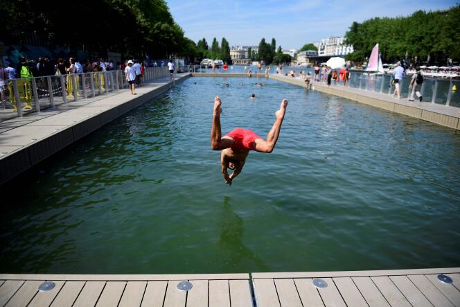 Un jeune homme plonge dans l’un des trois bassins inaugurés mardi 18 juillet par la Ville de Paris, au bassin de La Villette.