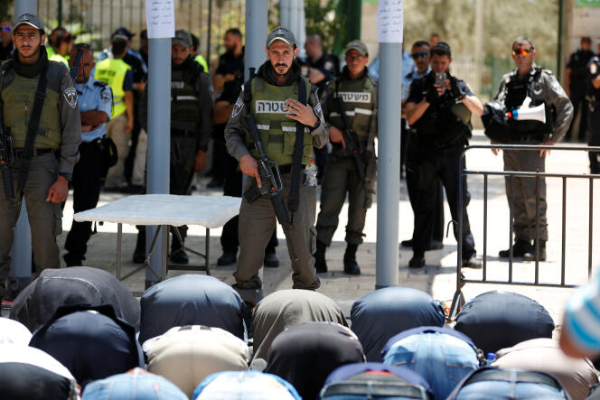 Des Palestiniens prient devant les portiques installés par la police israélienne, hors de l’esplanade des Mosquées, à Jérusalem, le 16 juillet.