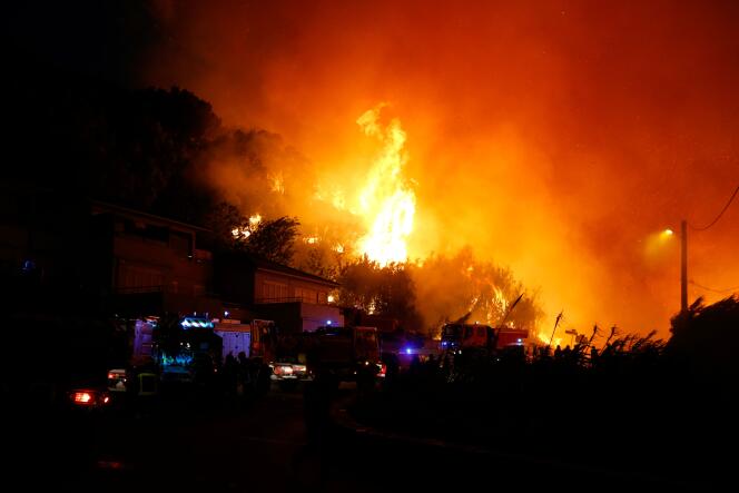 Les pompiers combattent un incendie menaçant des habitations sur la commune de Biguglia (Haute-Corse), le 24 juillet.