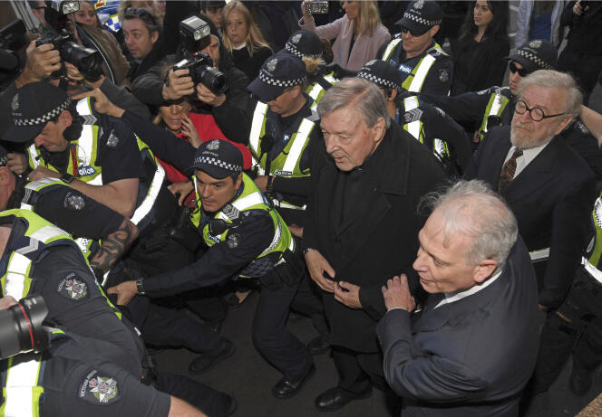 Cardinal George Pell, au centre, entouré par la police alors qu’il arrive au tribunal de Melbourne le 26 juillet 2017.