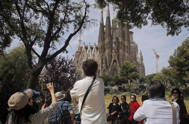 Des touristes prennent des photos, le 26 mai 2016, de la basilique de la Sagrada Familia, conçue par l’architecte Antoni Gaudi.