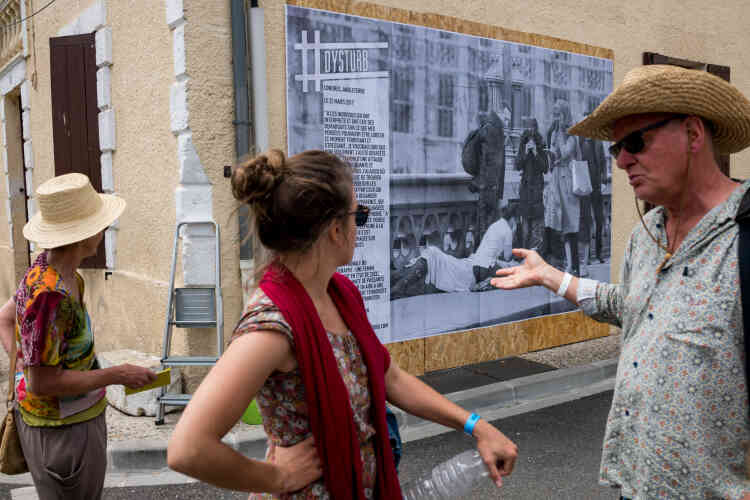 Des festivaliers devant une photo du Britannique Jamie Lorriman, affichée en grand format par le collectif Dysturb, liée à la thématique « S'informer à l'heure de la post-vérité ».
