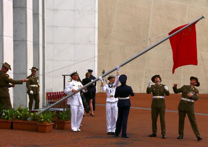 Des soldats australiens déploient  le drapeau chinois avant l’accueil officiel  du premier ministre de  la République populaire  de Chine, Li Keqiang,  devant  le Parlement,  le 23 mars,  à Canberra.