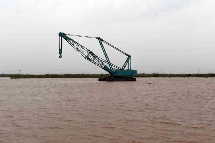 Une grue utilisée pour décharger les camions est perdue dans les eaux, à Maliya, dans le district de Morbi, à environ 200 kilomètres d’Ahmedabad.