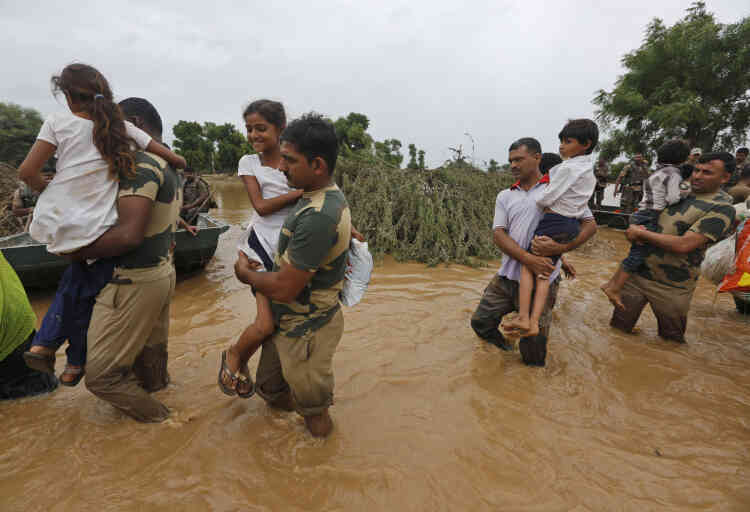 Des soldats portent les enfants des villages touchés par les inondations près de Thara dans le district de Banaskantha, au Gujarat.