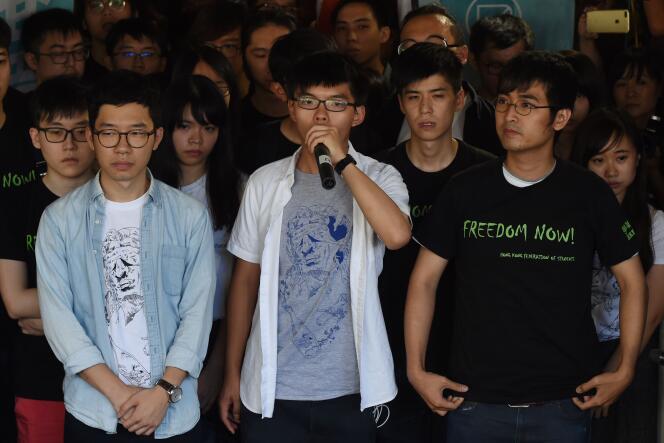 Joshua Wong (au centre), entouré par Nathan Law (à gauche) et Alex Chow (à droite), s’adresse aux médias avant l’énoncé de la peine des trois figures de proue du « mouvement des parapluies », à Hongkong, le 17 août 2017.