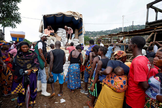 Des personnes déplacées par les coulées de boues torrentielles attendent de recevoir des produits de première nécessité, à Freetown, le 18 août.