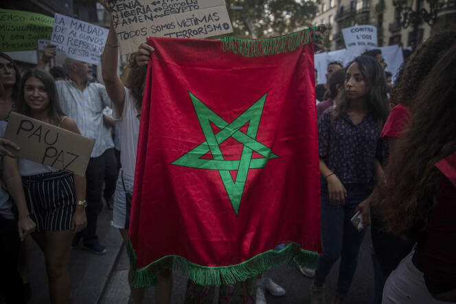 Une jeune femme brandit un drapeau marocain lors de la marche de la communauté musulmane contre le terrorisme, à Barcelone le 21 août.