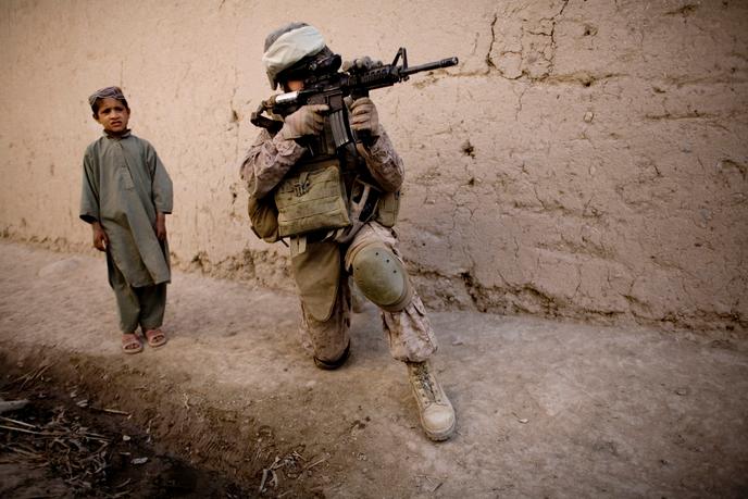 Un enfant afghan aux côtés d’un Marine durant une patrouille au sud de Kaboul (Afghanistan), le 3 novembre 2010.