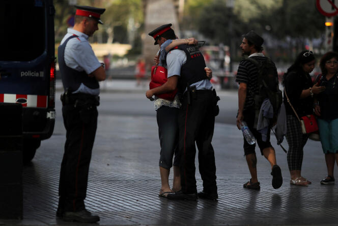 Une femme enlace un officier de la police catalane, la Mossos d’Esquadra, aux Ramblas de Barcelone où un attentat a coûté la vie à 13 personnes jeudi 17 août.