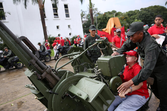 Un membre des forces armées bolivariennes explique le fonctionnement d’une canon anti-aérien lors de manoeuvres militaires organisées à Caracas, le 26 août.