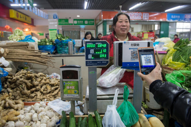 Un client utilise son smartphone pour payer ses courses dans un marché d’Hangzhou, dans la province de Zhejiang (Chine), en décembre 2015.