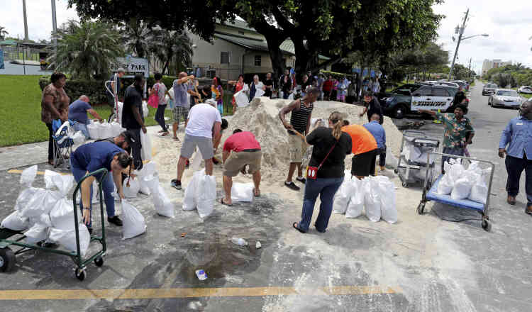 Des résidents font la queue au parc Frost, pour remplir des sacs de sable, à Dania Beach.