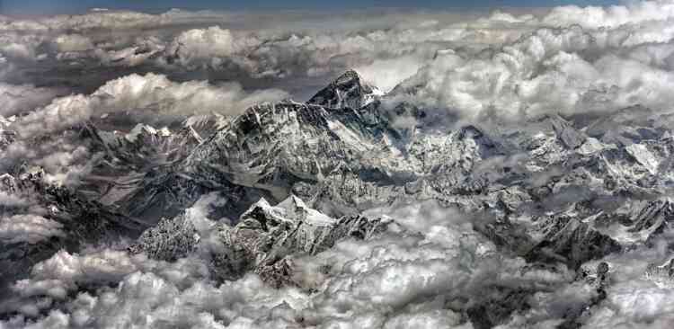 « L’Everest (8 848 mètres) vu d’avion entre Katmandou et Paro, au Bhoutan. Ce nom fut donné à la montagne en 1865 en l’honneur de sir George Everest, qui fut géographe en chef de la Grande-Bretagne en Inde. Dans les années 1960, le gouvernement népalais officialisa le nom Sagarmatha, qui peut être traduit diversement comme « front de l’océan », « front du ciel » ou « mère du ciel ». Au Tibet, où se trouve la face nord, l’Everest s’appelle Jomolangma, l’« altière déesse ». »