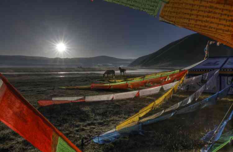 « Au petit matin, j’allais faire mes ablutions sur la rive du fleuve Dzatchou (qui devient le Mékong en dehors du Tibet), lorsque je suis tombé sur cette scène de chevaux et de drapeaux à prières dans la lumière du levant. »