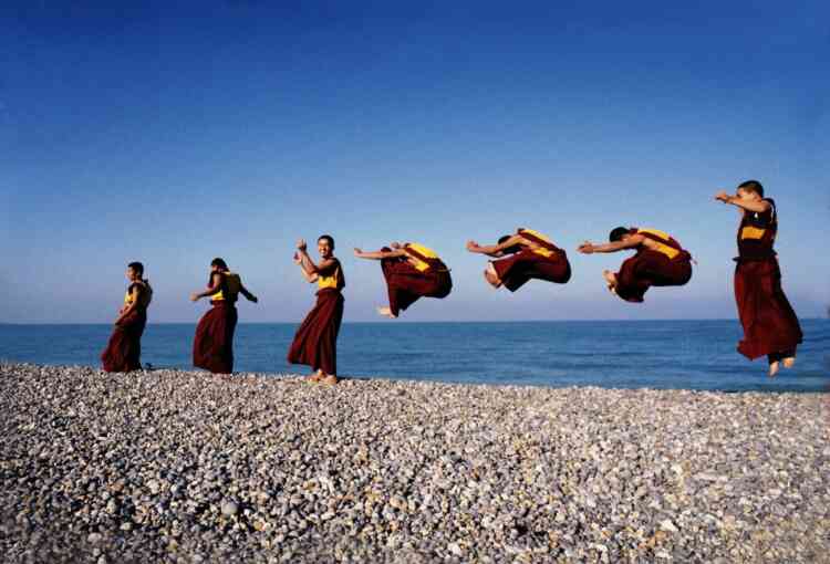 « Les moines volants du Toit du monde devant l’océan Atlantique au cours d’une tournée européenne de danses sacrées. Contrairement à ce que l’on pourrait croire, il ne s’agit pas d’un montage, mais bien d’un seul cliché de sept moines du monastère de Shechen, qui sautent de concert. »