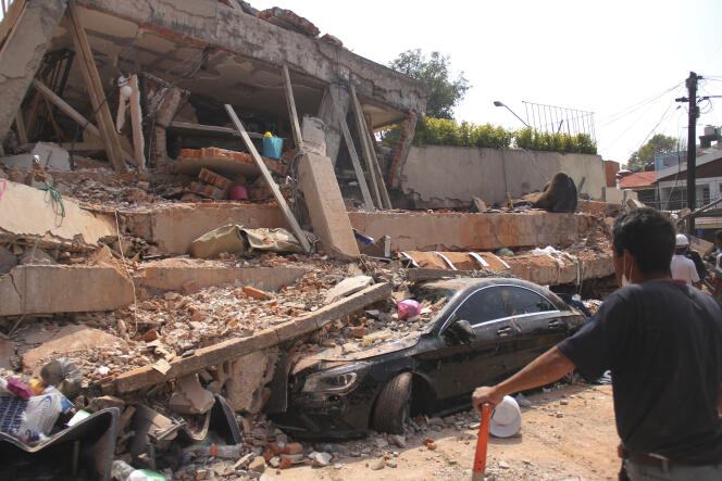 Une voiture écrasée devant les ruines du collège Enrique-Rebsamen où des dizaines d’enfants sont portés disparus, à Mexico, le 19 septembre.