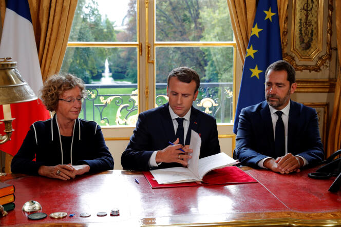 Emmanuel Macron, entouré de Muriel Pénicaud et Christophe Castaner, signe les ordonnances réformant le code du travail, à l’Elysée, le 22 septembre.