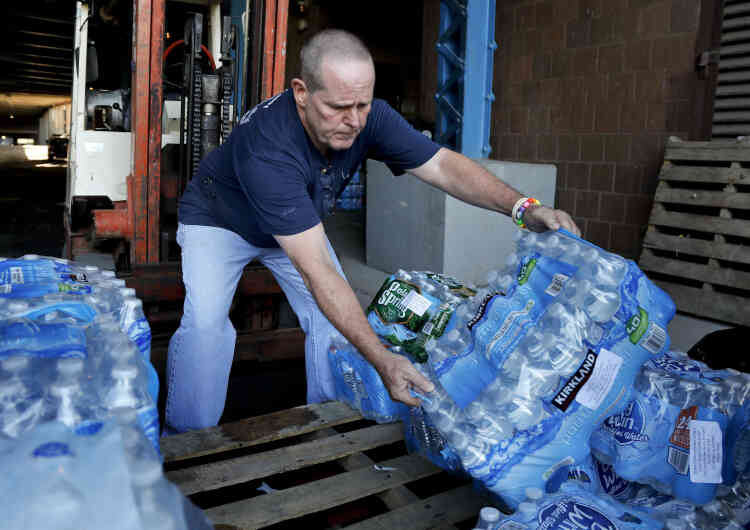 Un employé municipal américain empile des bouteilles d’eau afin de les offrir à l’organisation Empire State Relief and Recovery Effort for Puerto Rico, à New York.