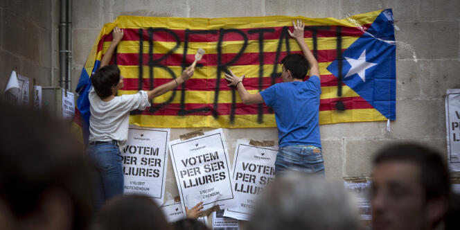 Des militants independantistes collent des affiches, pourtant interdites, en faveur du referendum murs de la mairie de Lleida, en Catalogne, le 21 septembre 2017.