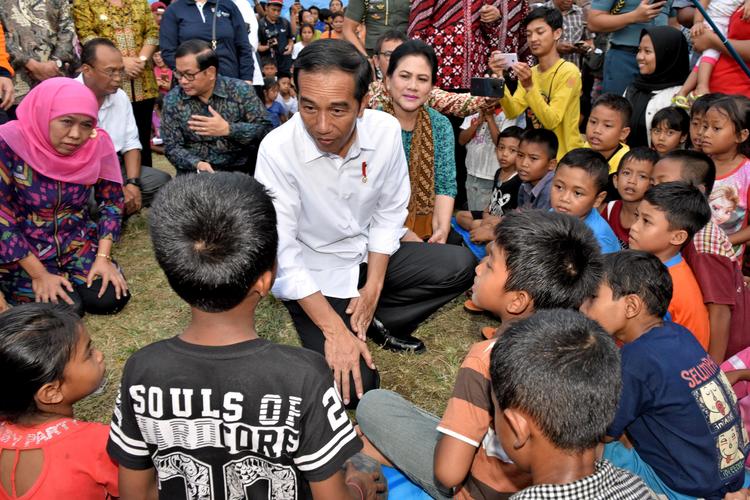 Le président indonésien, Joko Widodo, parle avec des enfants du camp de Karangasem.