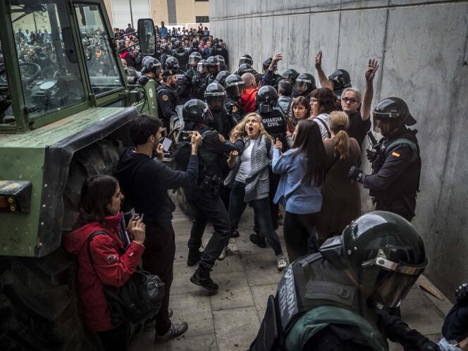 Les forces de l’ordre évacuent les personnes qui tentent de protéger le bureau de vote de Sant Julia de Ramis, le 1er octobre.