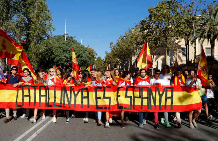 Des manifestants derrière une bannière qui indique, en catalan, les mots suivants : « La Catalogne, c’est l’Espagne ».