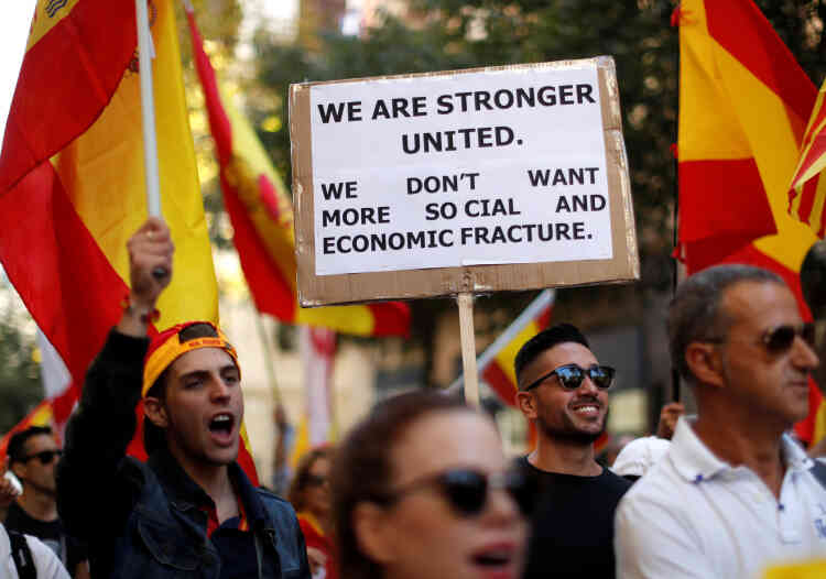 Un homme porte une pancarte indiquant « L’union nous rend plus fort. Nous ne voulons pas subir encore plus de fracture économique et sociale », lors de la manifestation pour l’unité, à Barcelone, le 8 octobre 2017.