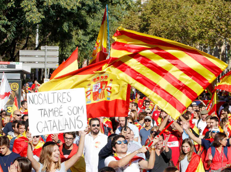 Une femme brandit une pancarte indiquant « Nous sommes Catalans, nous aussi ».