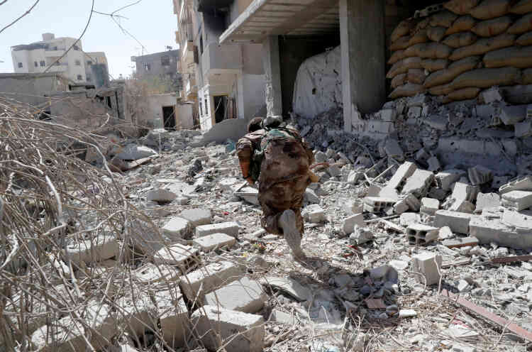 Un membre des Forces démocratiques syriennes tentent d’échapper aux tirs d’un sniper, près du stade de Rakka, le 4 octobre.