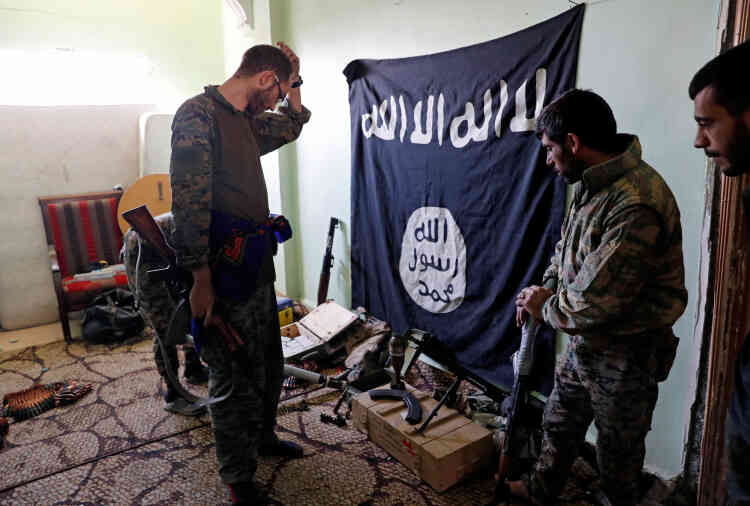 Des soldats des Forces démocratiques syriennes examinent des munitions et des armes prises aux combattants de l’EI, dans un immeuble situé sur la ligne de front, le 7 octobre.