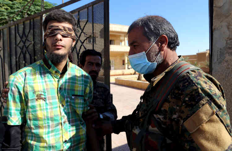 Un soldat des Forces démocratiques syriennes (à droite) escorte un civil suspecté d’être membre de l’EI, le 12 octobre.