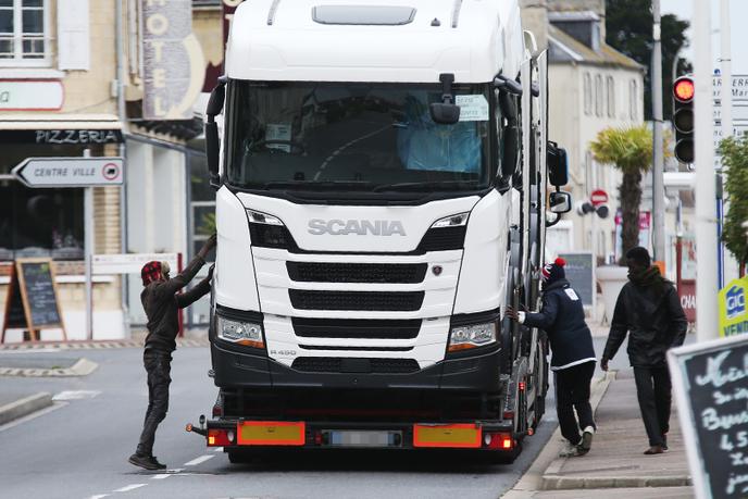Des migrants tentent de monter dans un camion en partance pour l’Angleterre. Trois ferries partent de Ouistreham (Calvados) tous les jours.