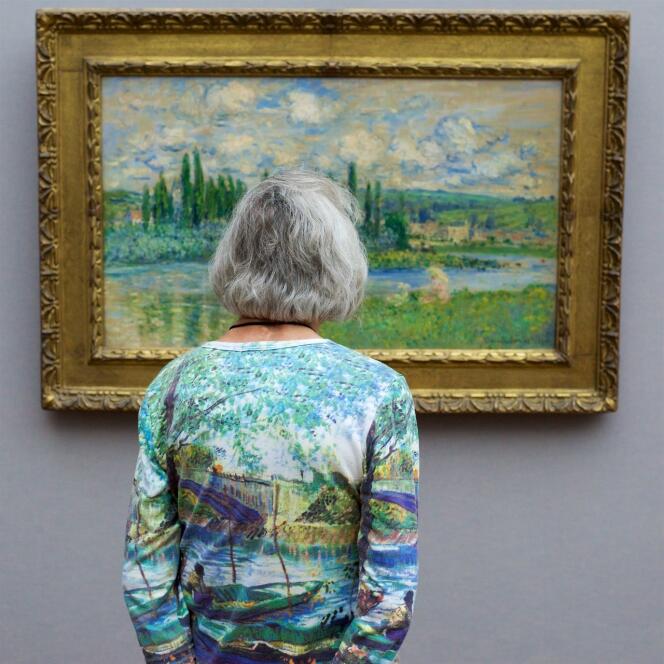 Une femme avec un T-shirt imprimé d’un tableau impressionniste admire une œuvre de Claude Monet, à Berlin.