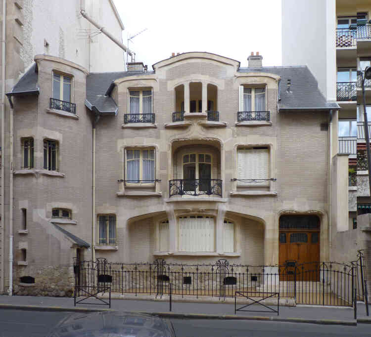 Sur la façade monochrome de la période assagie d’Hector Guimard (1910-1911), seuls les chéneaux ornés et les descentes en fonte sont manquants. On note une épitaphe de l’architecte en haut à gauche de l’entrée principale.