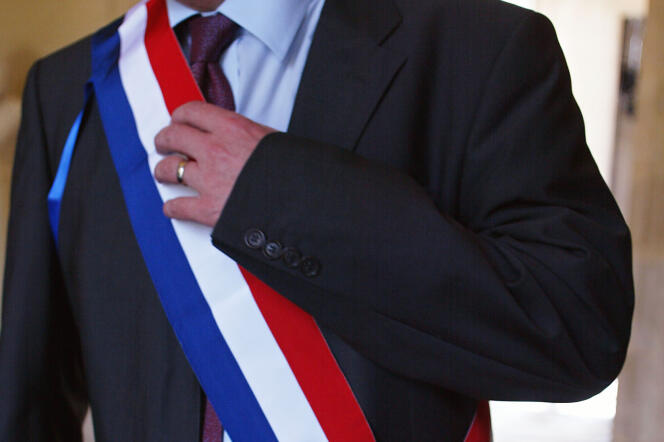 Un député vêtu de son écharpe tricolore, au Palais-Bourbon à Paris.