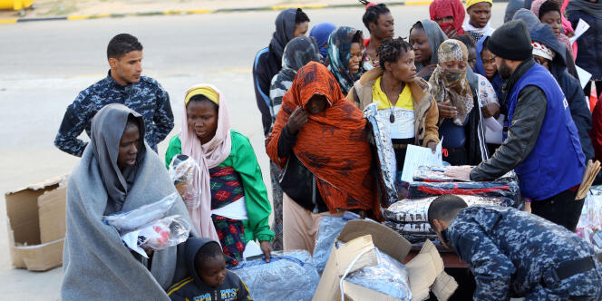 Des migrants subsahariens lors d’une distribution de vêtements dans un camp de rétention de la banlieue de Tadjourah, à l’est de Tripoli, en Libye, le 5 décembre 2017.