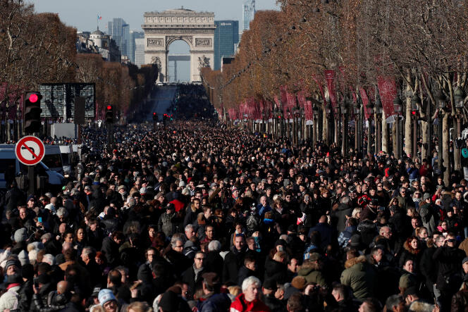 Sur les Champs Elysée, la foule derrière le cortège funéraire de Johnny Hallyday, le 9 décembre.