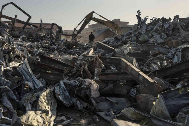 Un homme regarde les bulldozers au travail dans les ruines d’ateliers et de résidences  de Xinjian.