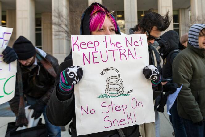 Une manifestante brandit un signe demandant de garder la neutralité du Net, le 13 décembre, à Washington.