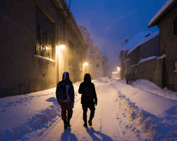 Deux jeunes migrants marchent dans Briançon pour rejoindre "Chez Marcel", un lieu d’hébergement alternatif pour migrants où ils pourront rester quelques jours.