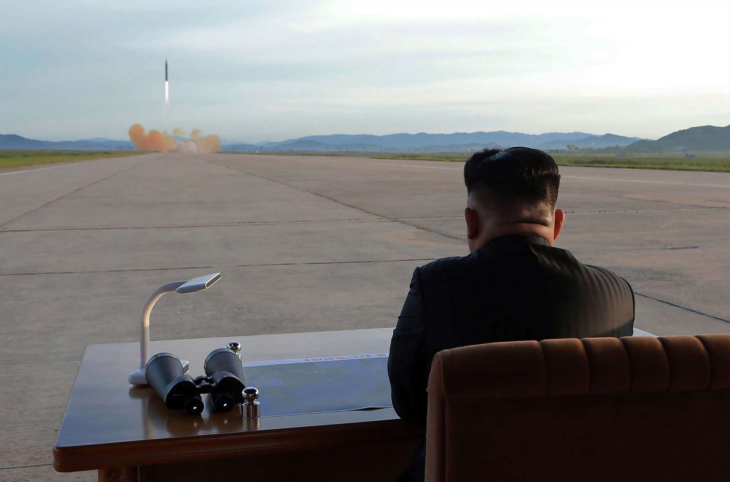 Cette photo non datée et publiée par l’Agence de presse officielle nord-coréenne (KCNA), le 16 septembre, montre le dirigeant nord-coréen Kim Jong-un assistant au lancement d’une fusée balistique stratégique à moyen et à long terme Hwasong-12, dans un lieu tenu secret. Kim Jong-un a promis de perfectionner la force nucléaire nord-coréenne malgré les sanctions, arguant que l’objectif final du développement des armes de son pays est « l’équilibre de la force réelle » avec les Etats-Unis.
