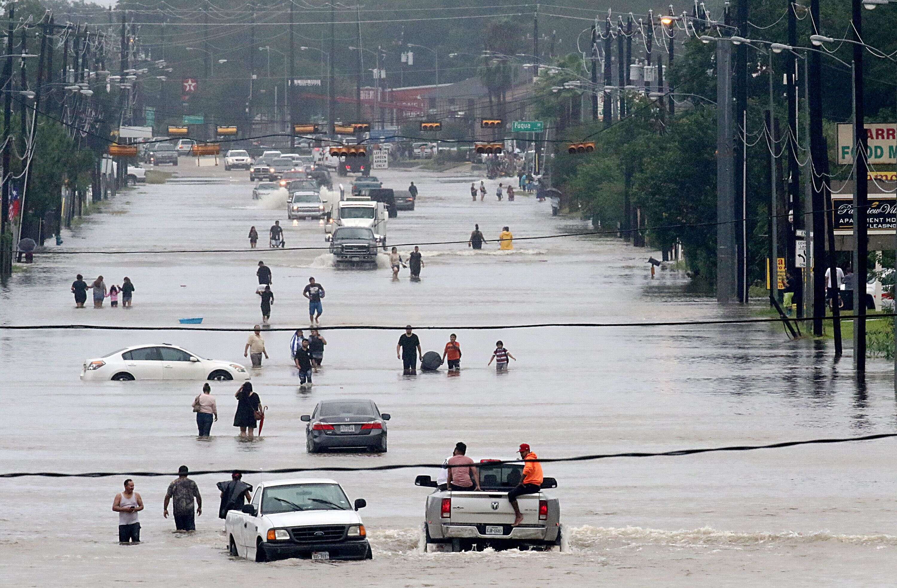 Des habitants marchent dans Telephone Road inondée, à Houston, alors que la ville affronte l’ouragan Harvey. Ce dernier, après avoir quitté le golfe du Mexique, a dévasté le Texas et la quatrième plus grande ville du pays, où trois personnes ont perdu la vie. La catastrophe naturelle a mobilisé douze mille soldats.