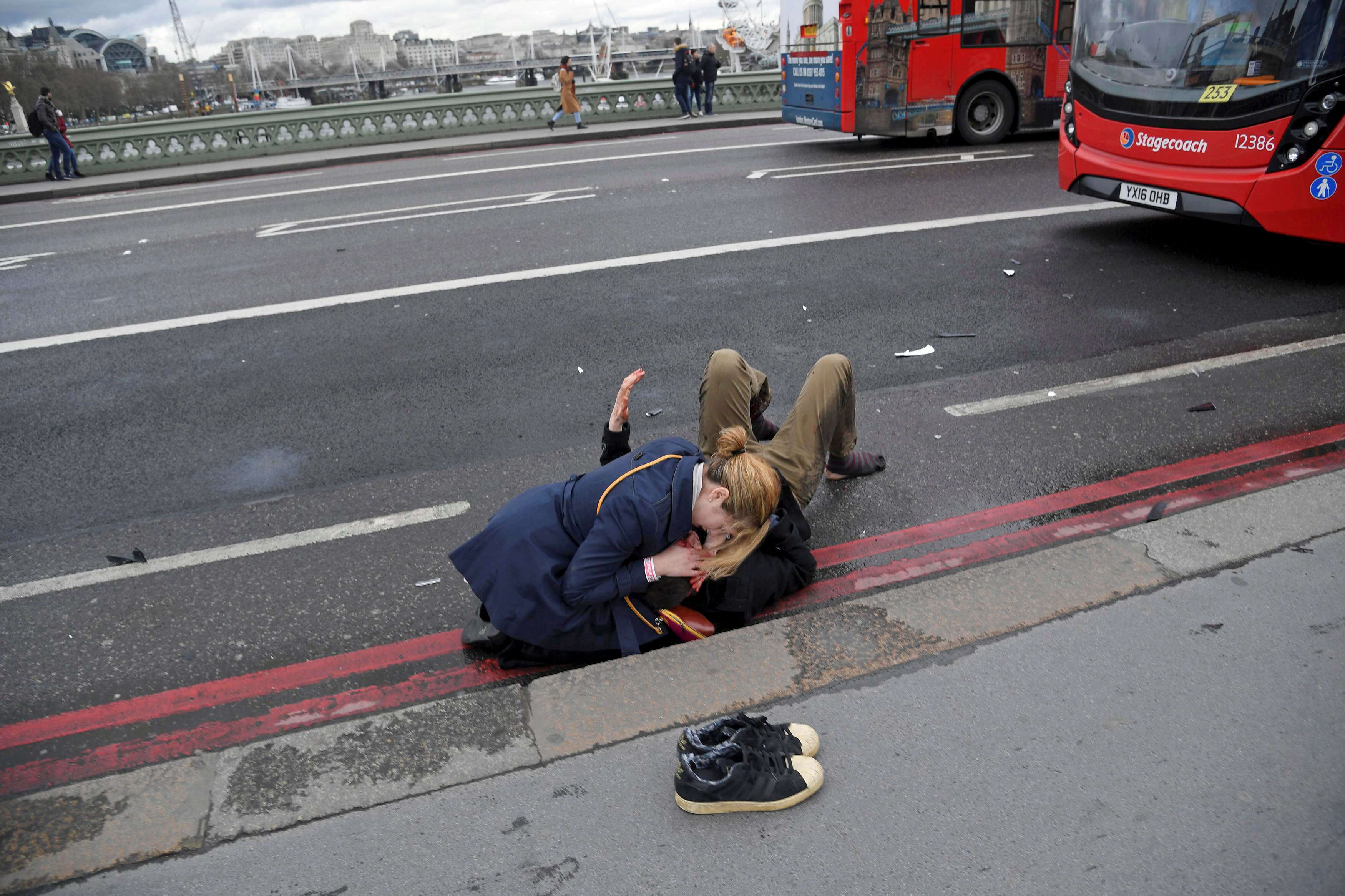 Une femme secourt une personne blessée dans un attentat à la voiture sur le pont de Westminster. Le photographe Toby Melville raconte : « J’étais sur le pont en train d’illustrer le Brexit. Je croyais que c’était un accident terrible, mais isolé. […] J’ai commencé à prendre des photos le long du pont, je ne savais pas si le danger était toujours présent. Je n’avais pas entendu de cris, de bruits de moteur bruyants ou les coups de feu de la police tirant et tuant l’auteur de l’attaque, Khalid Masood. »