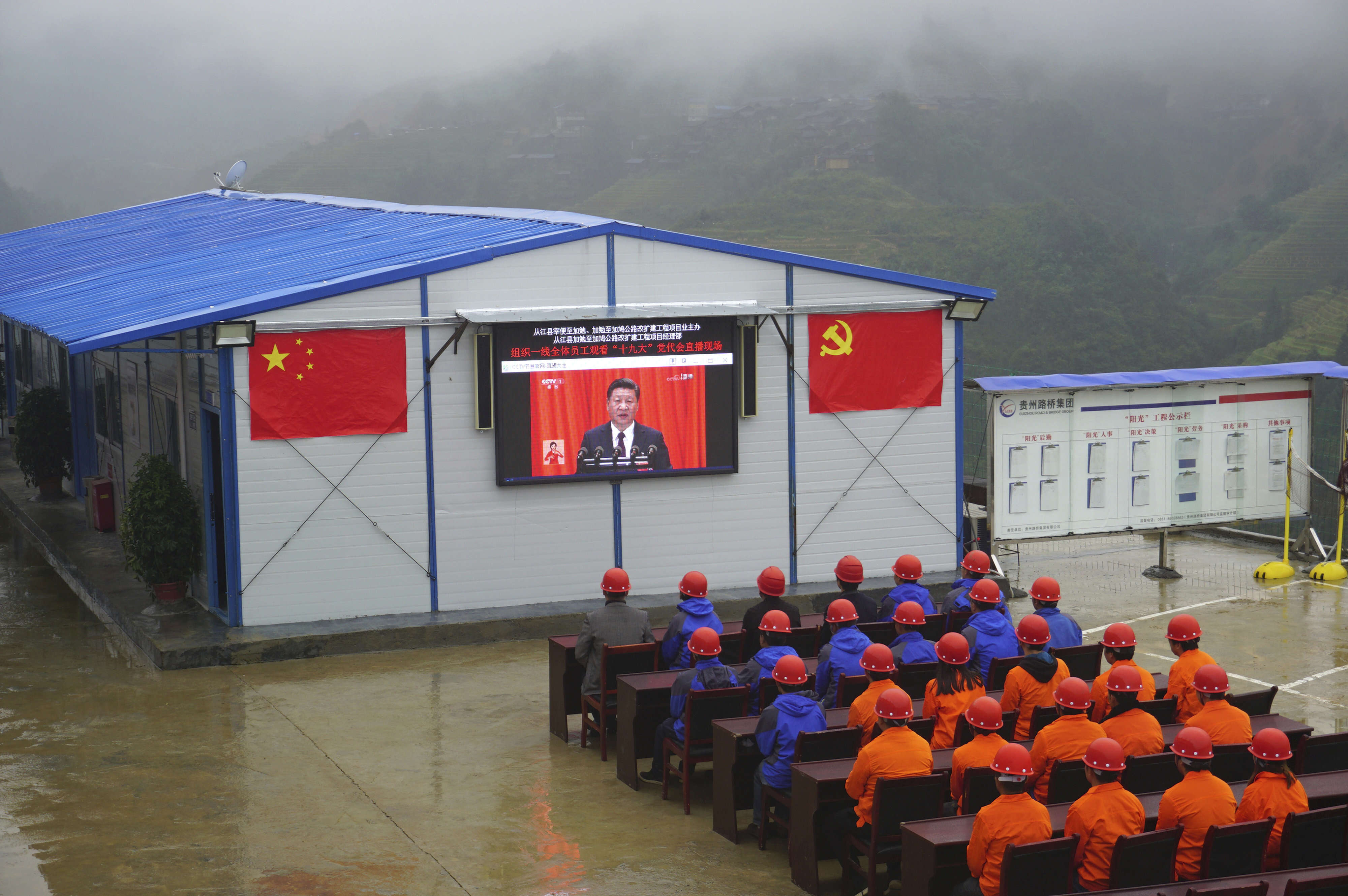 Des ouvriers d’une construction routière regardent le discours du président chinois Xi Jinping dans la région de Congjiang, situé dans le sud-ouest du pays. M. Xi a exposé, le 18 octobre, sa vision de la Chine dans un discours fleuve de plus de trois heures, lors de l’ouverture du 19e congrès du PCC, à Pékin. M. Xi a déroulé les accomplissements du parti pour les cinq années écoulées, mais aussi précisé l’ampleur des ambitions et des projets qu’il nourrit pour les cinq années à venir – et au-delà.